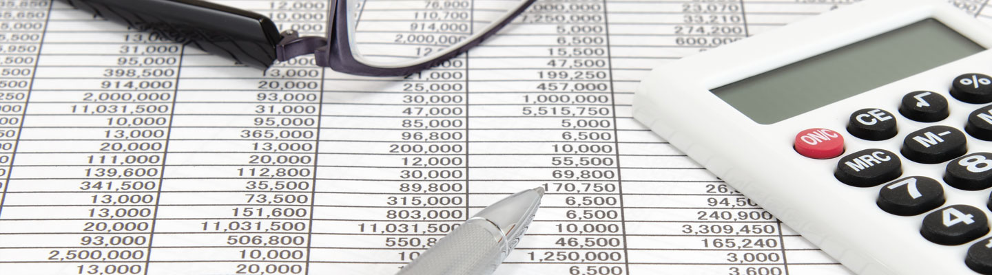 Calculatrice, stylo à bille et lunettes sur des documents de comptabilité