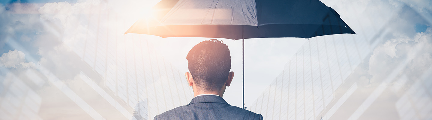 Double exposure image with a businessman holding an umbrella laid over a cityscape background